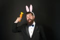 Gentleman with carrot. Easter rabbit black background. Bearded man hold carrots. Happy elegant businessman wear rabbit