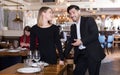 Gentleman helping woman with her chair in restaurant Royalty Free Stock Photo