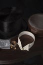 Gentleman\'s top hat, cravat, collar, collar studs and leather collar box on a dark wood table