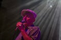 A gentleman singing with a microphone in a spotlight