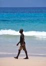 A gentleman strolls along the beautiful beau vallon beach in mahe island, seychelles Royalty Free Stock Photo