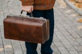 Man with carpetbag in jacket stands in alley of autumn park Royalty Free Stock Photo