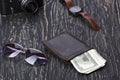 Gentlemanly set: sunglasses, wallet, camera, watch on wooden background Royalty Free Stock Photo