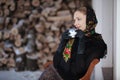 Gentlewoman sitting with cap of tea outdoors at winter