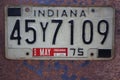 Indiana USA License Plate on a rusty metal background.