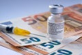 Genuine Pfizer BioNTech COVID-19 Vaccine vial placed on Euro banknotes. Real vaccine photo.