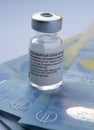 Genuine Pfizer BioNTech COVID-19 Vaccine vial placed on Euro banknotes. Real vaccine photo.