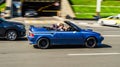 Geo Metro Convertible old car driving on the street. Blue Suzuki Swift convertible in motion Royalty Free Stock Photo