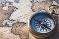 Geo navigation concept vintage style compass on ancient world map backdrop