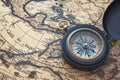 Geo navigation concept vintage style compass on ancient world map backdrop