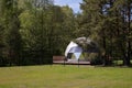 Geodesic dome in verdant forest clearing with lush greenery and sky view Royalty Free Stock Photo