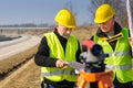 Geodesist two man theodolite stand highway Royalty Free Stock Photo