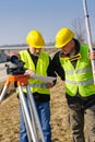 Geodesist two man theodolite stand highway