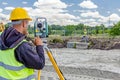 Geodesist is working with total station on a building site. Civi