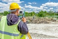 Geodesist is working with total station on a building site. Civi