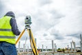 Geodesist is working with total station on a building site. Civi