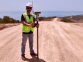 Geodetic engineer surveyor in white hard hat doing measurements with GNSS satellite receiver Royalty Free Stock Photo