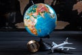 Geographical globe on the background of a black map with a small tourist plane