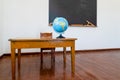 For the geography lesson, the globe stands on the teacher`s desk. Tools and materials for math lesson stand on the chalkboard Royalty Free Stock Photo