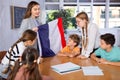 Geography lesson in school class - teacher talks about France, holding flag in his hands Royalty Free Stock Photo