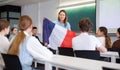 Geography lesson in school class - teacher talks about France, holding flag in his hands Royalty Free Stock Photo