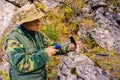 Geologist examines a mineralogical sample with the help of a geological hammer Royalty Free Stock Photo