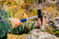 Geologist examines a mineralogical sample with the help of a geological hammer Royalty Free Stock Photo