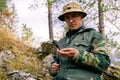 Geologist examines a mineralogical sample with the help of a geological hammer