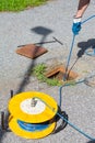 Geologist taking inclinometer readings on road, measuring slope stability.