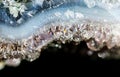 Gemstone Amethyst closeup as a part of cluster geode filled with rock Quartz crystals.