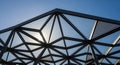A geometric architectural structure with a metal framework forms triangular patterns, Royalty Free Stock Photo