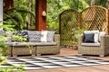 Geometric carpet on wooden veranda with garden furniture with pi