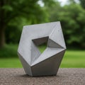 Geometric concrete sculpture with angular design and a triangular cutout sits on a Royalty Free Stock Photo