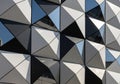 Geometric facade featuring a pattern of triangular panels, including metallic and reflective Royalty Free Stock Photo