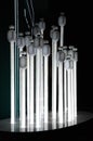 Geometric lines of shiny light bulbs in shape of long white installations on black background. Unusual lighting equipment. Modern Royalty Free Stock Photo