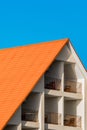 Geometric modern building facade exterior with orange tiled roof. Hotel against a blue sky Royalty Free Stock Photo