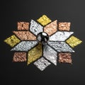 Geometric pattern of gold silver and copper textured foil surrounding a shiny black ball Royalty Free Stock Photo