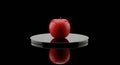 Geometric red apple artwork on a dark pedestal Royalty Free Stock Photo