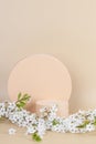 Geometric round podium platform stand for product presentation and spring blooming tree branch with white flowers on