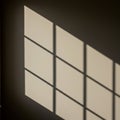 Geometric shadow of a window frame cast on a wall. The shadow forms a grid pattern Royalty Free Stock Photo