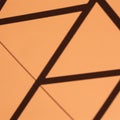 Geometric shadows cast on a textured orange surface create a pattern of intersectin Royalty Free Stock Photo
