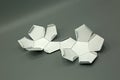 Geometric shape cut out of paper and photographed on grey background.Dodecahedron. 2d shape foldable to form a 3d shape or a solid