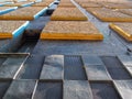 Geometric textured facade of an old concrete brutalist building with repeating square shapes and tiles and orange painted sections