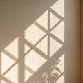 Geometric Triangle Shadows on Beige Plaster Wall with Filtered Sunlight Indoor Royalty Free Stock Photo