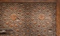 Geometrical engraved decorations of an aged wooden ornate door leaf