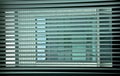 Geometries at the window. Venetian blinds at the office window create an interesting game of colors and colors by drawing a grid