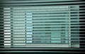 Geometries at the window. Venetian blinds at the office window create an interesting game of colors and colors by drawing a grid Royalty Free Stock Photo