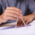 Geometry matters. Closeup shot of a draftsman using a triangle and compass to draw up building plans.