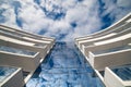 Geometry and perspective in architecture. Facade of a building and blue sky with clouds. Royalty Free Stock Photo