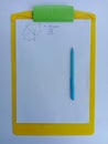 Geometry Problem Solving on A White Paper pinned on a Yellow Clipboard